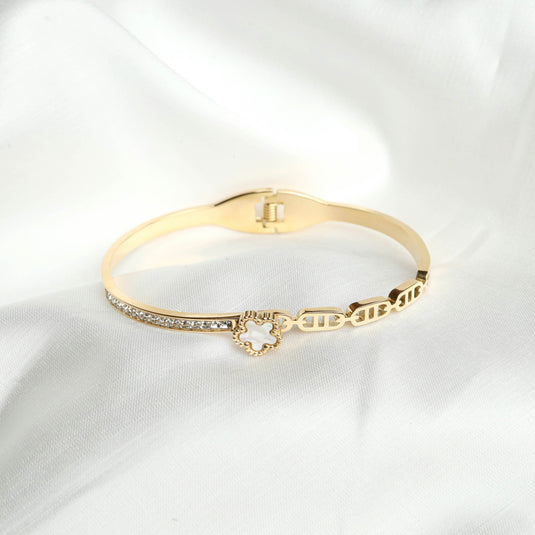 QuinShine Bella Flora link bracelet in gold with delicate floral charm and crystal accents on white fabric