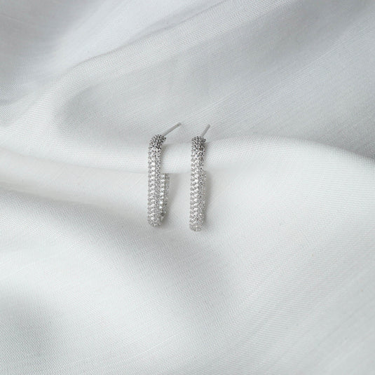 QuinShine silver sparkling elongated hoop earrings for women displayed on white fabric