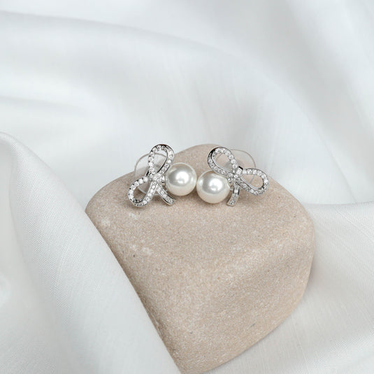 QuinShine loop design earrings with pearl and sparkling rhinestones on fabric background