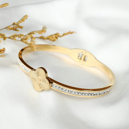 QuinShine Lustre Lily Bracelet gold tone with flower charm and crystal accents on white fabric