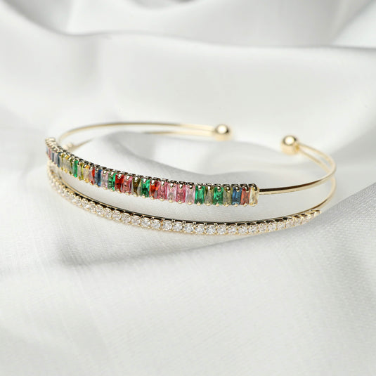 QuinShine elegant multicolor jewelry bracelet with gold bands and colorful gemstones on white fabric