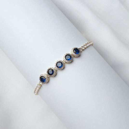 QuinShine Ocean Gaze tennis bracelet with blue gemstones and silver setting on white background