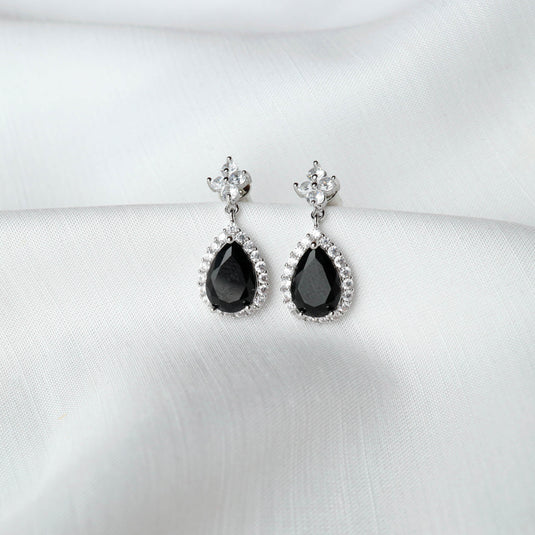 QuinShine teardrop gemstone earrings with black stones surrounded by small clear crystals on a silver setting