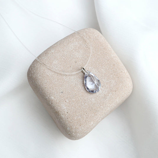 QuinShine crystal drop necklace with clear teardrop pendant on a transparent cord display