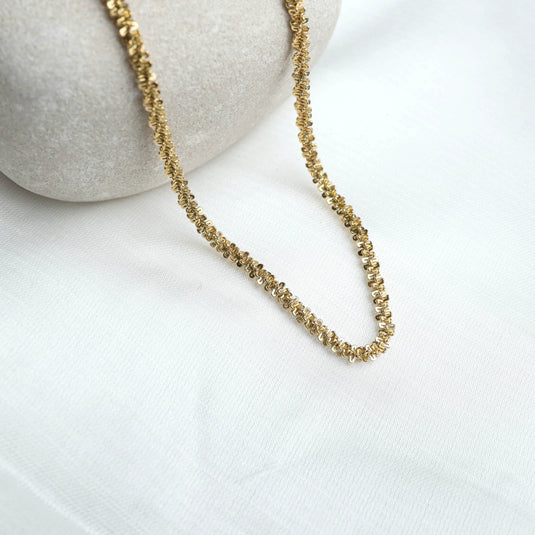 QuinShine delicate chain necklace for women in gold tone displayed on white fabric and stone background