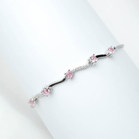Delicate rose gold bracelet with pink gemstones and silver detailing on white background