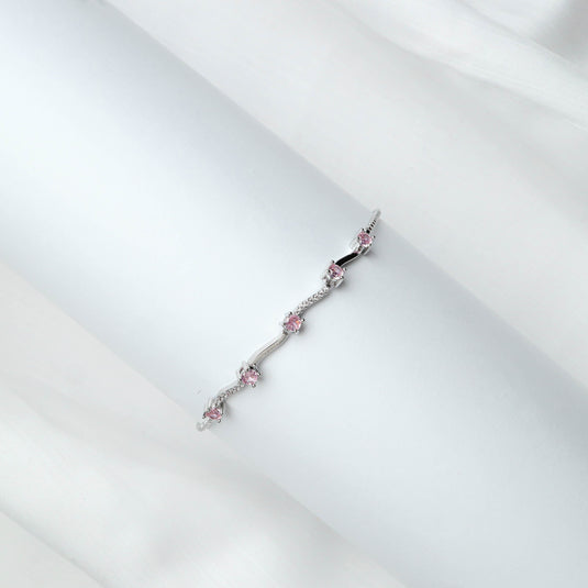 QuinShine delicate rose gold bracelet with pink gemstones on white fabric background