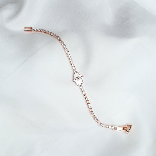 QuinShine Divine Grace Protective Charm bracelet with rose gold chain and hamsa hand charm on white fabric