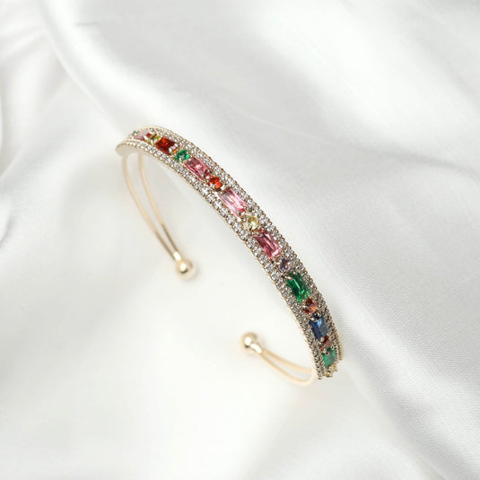 QuinShine elegant cuff bracelet with multicolored gemstones and gold-tone setting on white fabric
