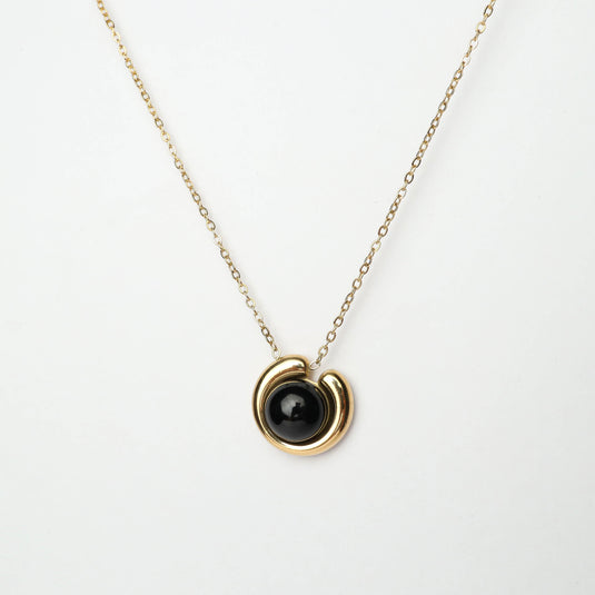 Elegant Eclipse Pendant Jewelry with black stone and gold circular design on delicate chain