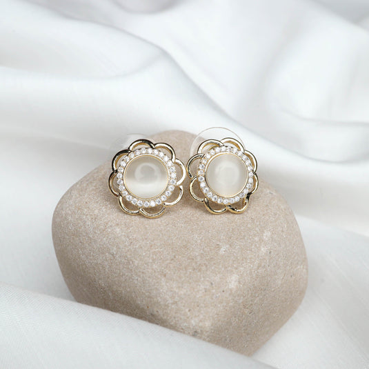 QuinShine Elegant Flower Stud Earrings with gold petals and pearl center displayed on stone