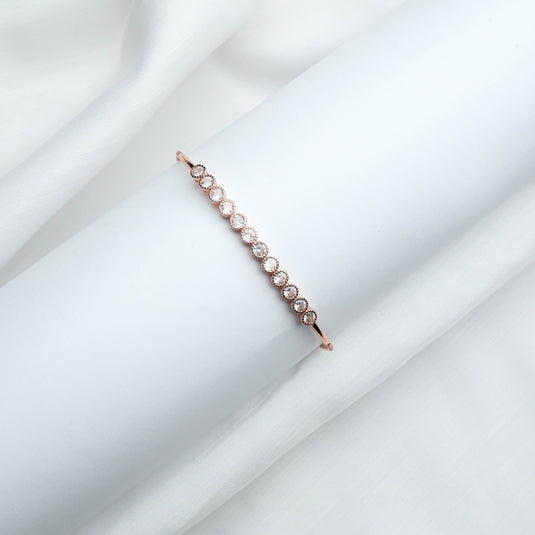 QuinShine elegant rose gold bracelet with sparkling round stones on white fabric background