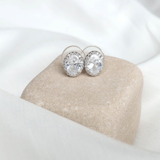 QuinShine elegant silver jewelry oval crystal stud earrings on beige stone display