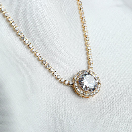 Gold elegant tennis necklace jewelry with round central diamond pendant surrounded by smaller stones