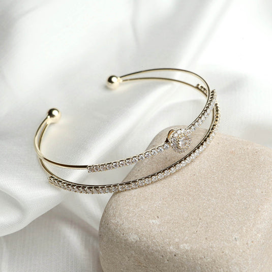 QuinShine elegant gold Embrace Brilliance Bracelet with sparkling crystals on white fabric background