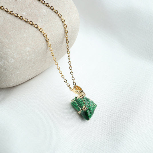 Emerald embrace necklace with green stone pendant on gold chain from QuinShine jewelry