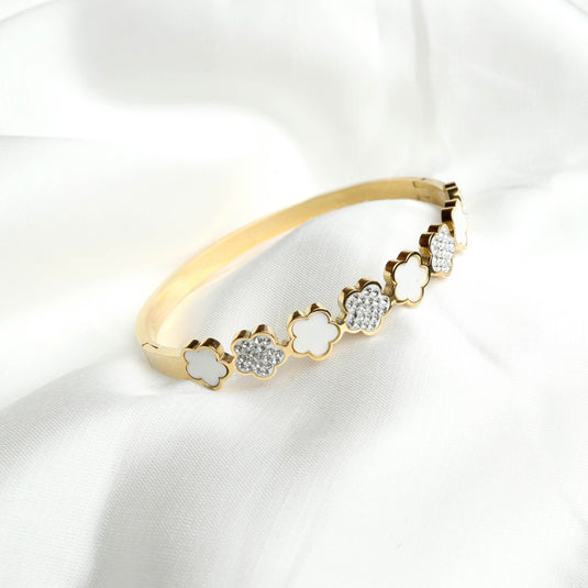 QuinShine floral gold bracelet with alternating white enamel and crystal flower designs on a gold band