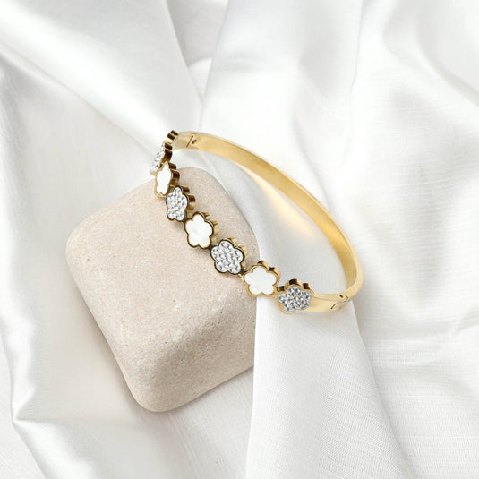 QuinShine floral gold bracelet with alternating white and crystal flower designs on a gold band