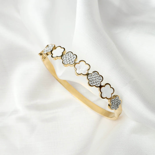 QuinShine floral gold bracelet with alternating white and crystal flower designs on a delicate band