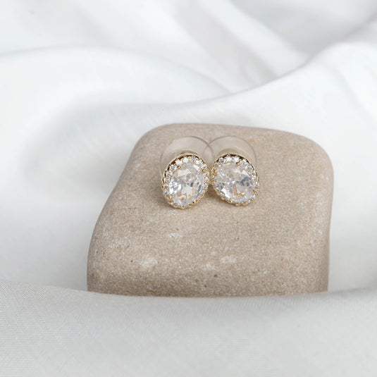 QuinShine aura oval stud earrings with clear oval gemstones and gold setting on neutral stone