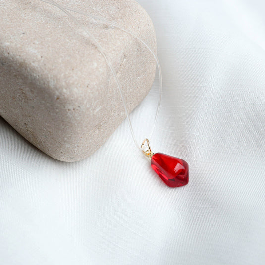 Elegant sheer necklace by QuinShine featuring a clear cord with a red teardrop pendant