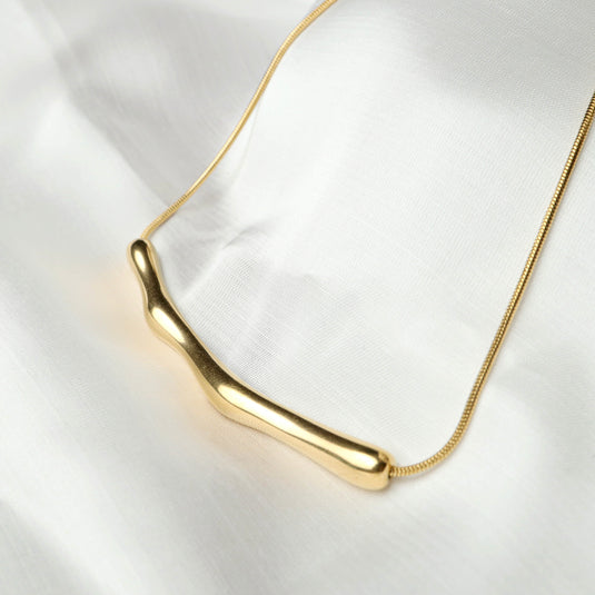 Elegant gold bar necklace with smooth curved design on a delicate chain by QuinShine