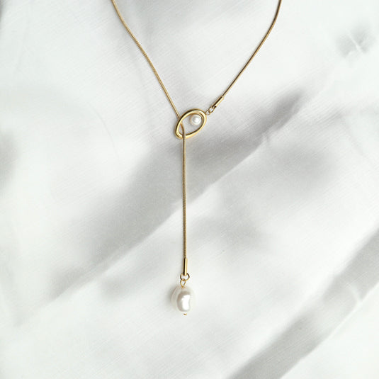 QuinShine baroque pearl lariat necklace with gold chain and irregular pearl drops on white fabric
