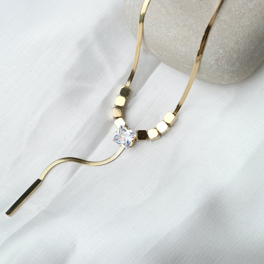 QuinShine diamond pendant lariat necklace with gold chain and square crystal on white fabric