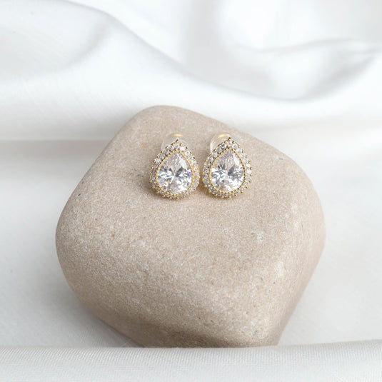 QuinShine elegant gold drop earrings with teardrop shaped clear crystals on beige stone