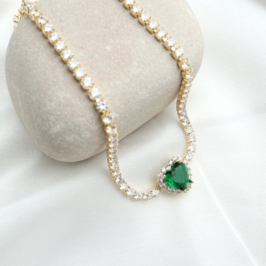 Gold emerald jewelry necklace with heart-shaped green emerald and surrounding clear stones