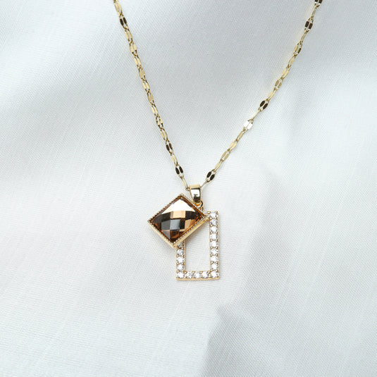 Gold geometric pendant necklace with a faceted square and a rectangular frame adorned with crystals
