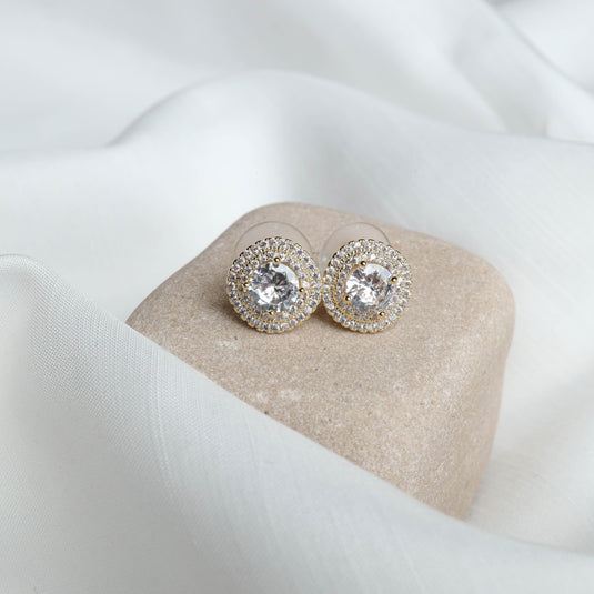 QuinShine gold halo earrings with clear central stones and sparkling small crystals on beige display