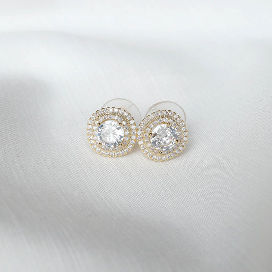 QuinShine gold halo earrings with sparkling round cubic zirconia stones on white fabric background