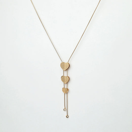 Elegant gold heart lariat necklace with three heart-shaped pendants in varying sizes