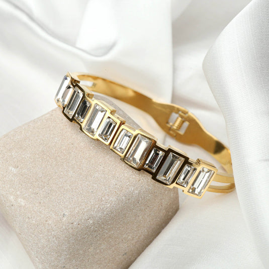 QuinShine high-end fashion bracelet with gold tone and rectangular clear gemstones on beige stone
