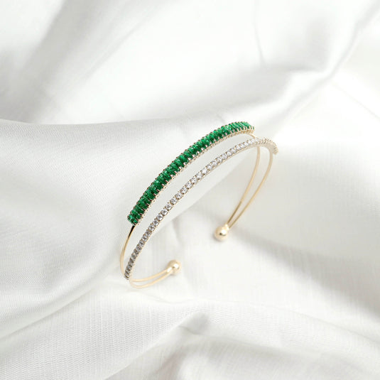 QuinShine elegant gold plated emerald bangle with green emerald stones and clear crystals on white fabric