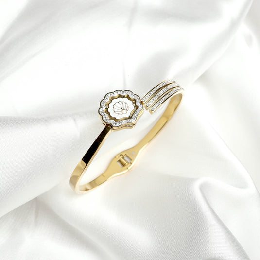 QuinShine elegant gold shell bracelet with crystal accents on a white fabric background