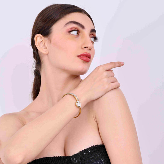 QuinShine elegant gold shell bracelet worn on wrist by woman in black strapless dress