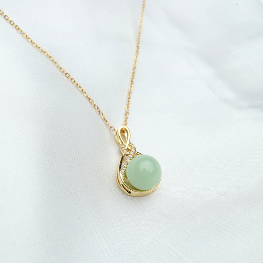 QuinShine jade pendant necklace with round green jade stone and gold chain on white background