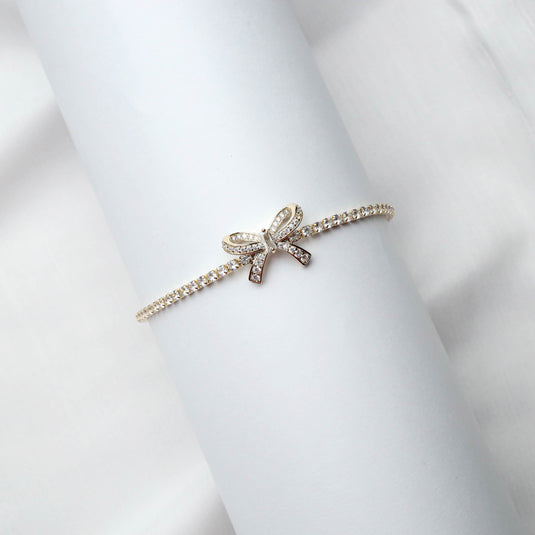 QuinShine delicate diamond accent bow bracelet on white cylindrical display