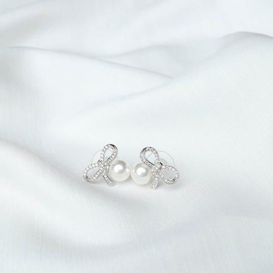 QuinShine elegant loop design earrings with pearls and sparkling crystals on white fabric background