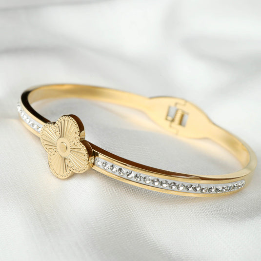QuinShine Lustre Lily Bracelet gold tone with crystal accents and flower charm on white fabric