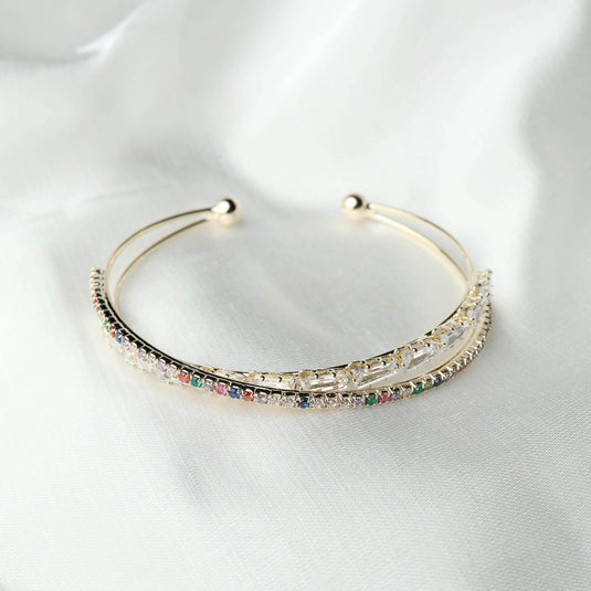 QuinShine delicate gold open cuff rainbow gemstone bracelet with multicolored stones on white fabric