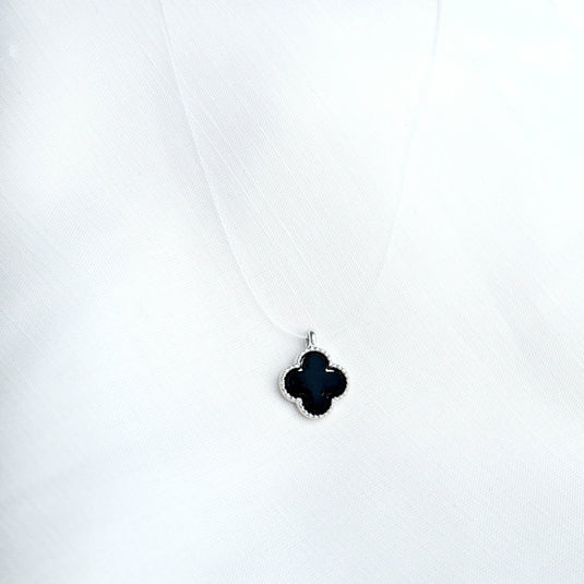 Midnight Clover necklace by QuinShine featuring a black clover-shaped pendant on a delicate chain