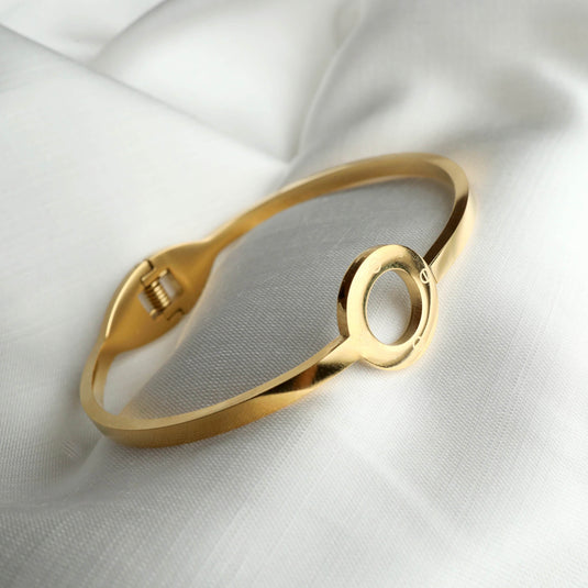 QuinShine minimalist jewelry bracelet in gold with circular design on white fabric background
