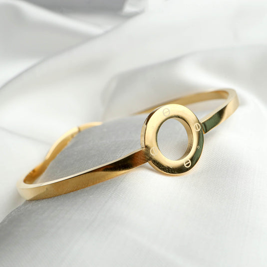 Gold minimalist jewelry bracelet by QuinShine with a sleek circular design on a white fabric background