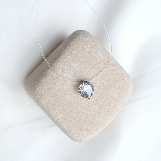 QuinShine minimalist jewelry necklace with a clear single round crystal pendant on a transparent cord