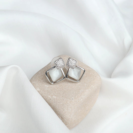 QuinShine silver Opal gemstone earrings with square design and sparkling accents on beige stone