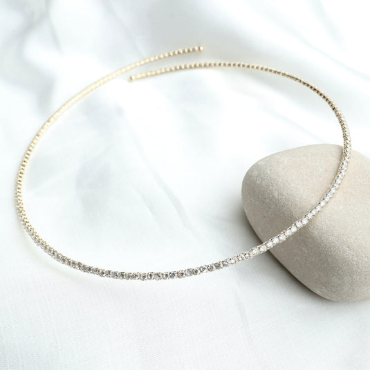 QuinShine open diamond necklace with delicate gold setting displayed on a white fabric background