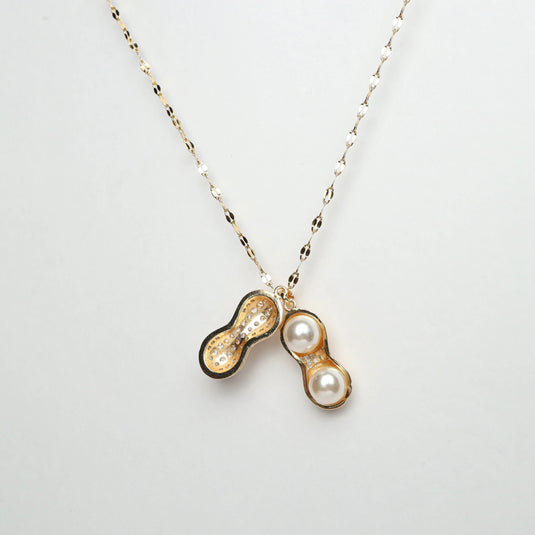 QuinShine peanut shell locket necklace with gold chain and pearl details inside the locket
